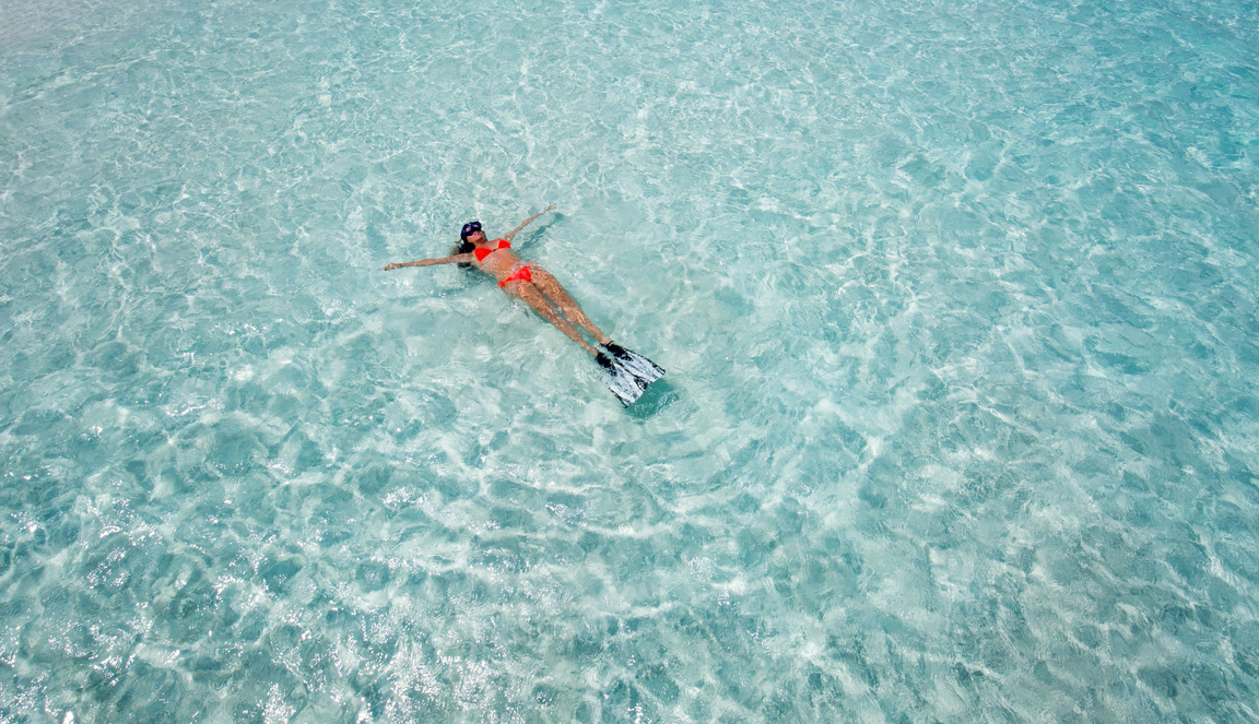 Woman floating on crystal clear waters